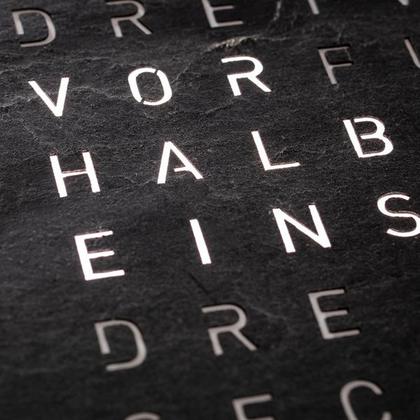 Qlocktwo Earth 45 Creator's Edition Metamorphite mit schwarz lackiertem Holz – Großuhren Wanduhr aus Eisen. Das Gehäuse ist quadratisch und weiß. Das Zifferblatt ist digital und grau. – Ansicht 2