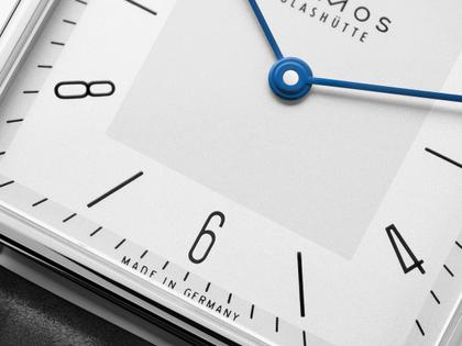 Nomos Glashütte Tetra 27 Duo Handaufzug Edelstahl 27mm weißes Zifferblatt schwarzes Lederband Stahlboden – Damenuhren Uhr ohne Datum aus Edelstahl und Leder. Das Gehäuse ist quadratisch und silber. Das Lederarmband ist schwarz. Das Zifferblatt ist arabisch Index und weiß. – Ansicht 3