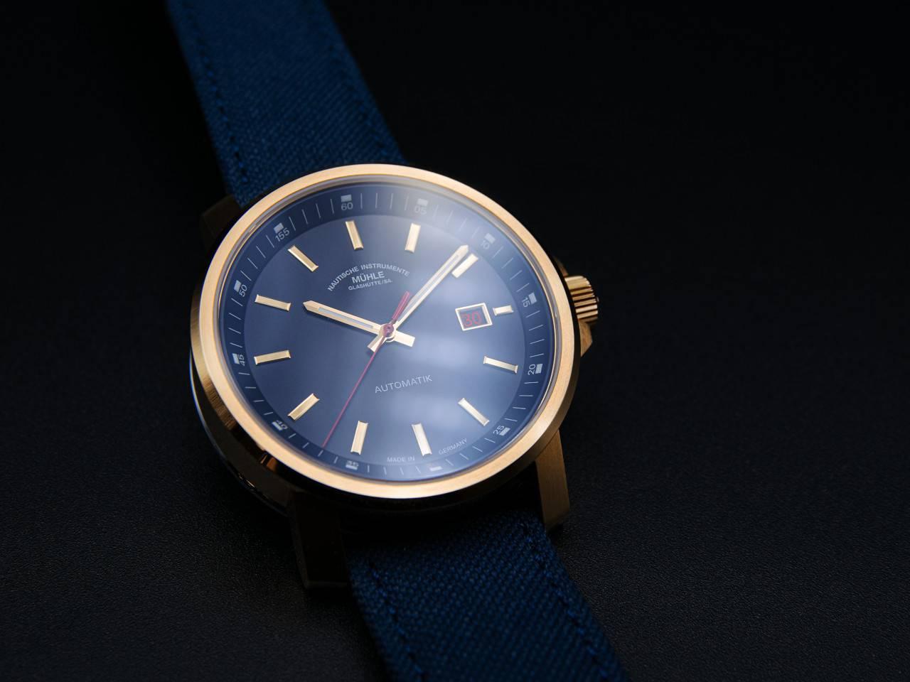Mühle Glashütte 29er Big Bronze Edition 1994 Automatik 42,4mm blaues Zifferblatt blaues Canvasband – Herrenuhren Uhr mit Datum aus Bronze und Edelstahl. Das Gehäuse ist rund und roségold. Das Textilarmband ist blau. Das Zifferblatt ist ein Index in weiß. – Ansicht 2