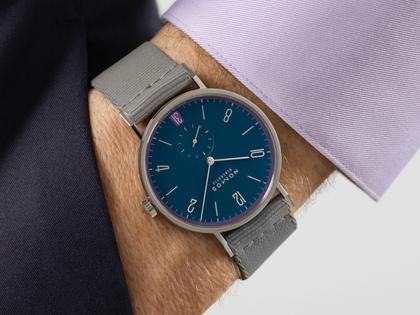 Nomos Glashütte Tangente 38 Datum "175 Years Watchmaking - Nachtgesang" Handaufzug Edelstahl blaues Zifferblatt graues Textilband Glasboden – Herrenuhren Uhr mit Datum aus Edelstahl. Das Gehäuse ist rund und silber. Das Textilarmband ist grau. Das Zifferblatt ist arabisch Index und blau. – Ansicht 7