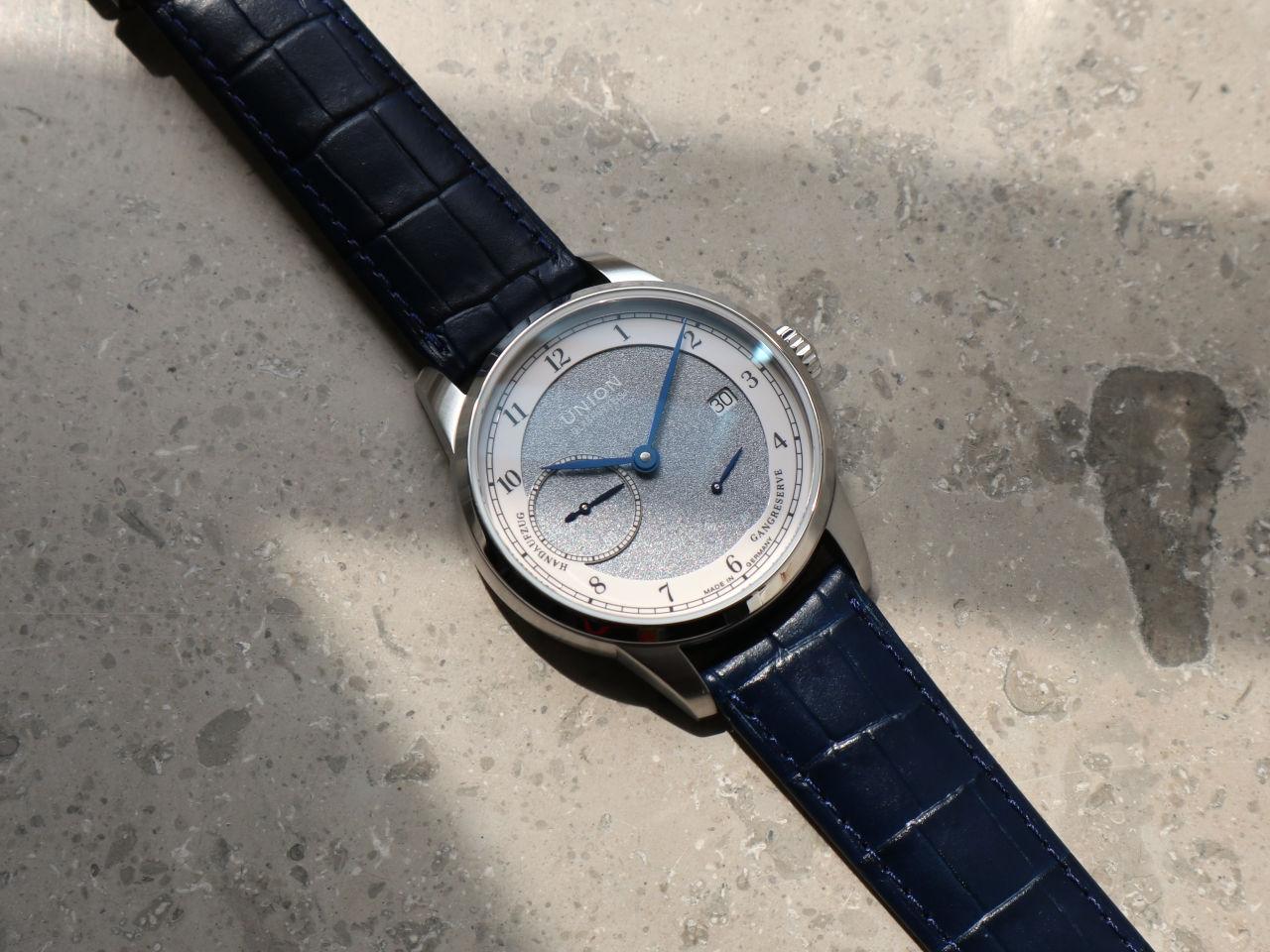 Union Glashütte 1893 Johannes Dürrstein Edition Gangreserve Handaufzug Edelstahl 41mm graues Zifferblatt blaues Lederband – Herrenuhren Uhr mit Datum aus Edelstahl und Leder. Das Gehäuse ist rund und silber. Das Lederarmband ist blau. Das Zifferblatt ist arabisch und grau. – Ansicht 3