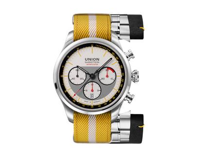Union Glashütte Belisar Chronograph Silvretta Classic 2026 Limitierte Edition Automatik Edelstahl 44mm beiges Zifferblatt gelbes Textilband schwarzes Lederband und Metallband – Herrenuhren Chronograph aus Edelstahl und Leder. Das Gehäuse ist rund und silber. Das Textilarmband ist gelb. Das Zifferblatt ist ein Index in beige.