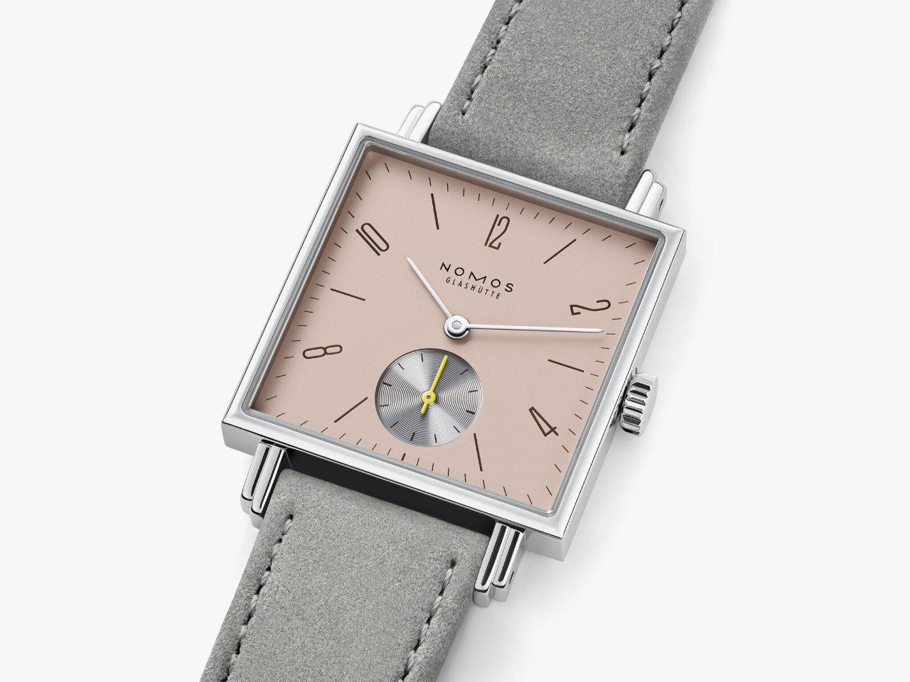Nomos Glashütte Tetra Die Kapriziöse Handaufzug Edelstahl 29mm beiges Zifferblatt graues Veloursband Glasboden – Damenuhren Uhr ohne Datum aus Edelstahl und Leder. Das Gehäuse ist quadratisch und silber. Das Lederarmband ist grau. Das Zifferblatt ist arabisch Index und beige. – Ansicht 3
