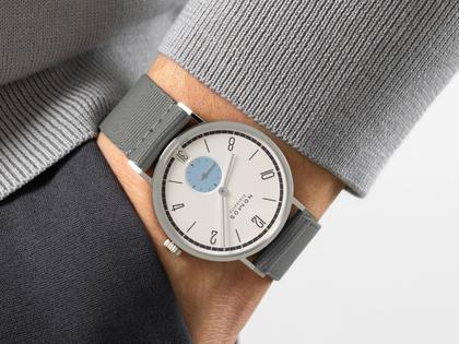 Nomos Glashütte Tangente 38 Datum "175 Years Watchmaking - Schneesturm" Handaufzug Edelstahl cremeweißes Zifferblatt graues Textilband Glasboden – Herrenuhren Uhr mit Datum aus Edelstahl. Das Gehäuse ist rund und silber. Das Textilarmband ist grau. Das Zifferblatt ist arabisch Index und beige. – Ansicht 7