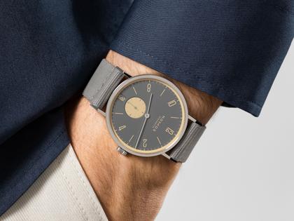 Nomos Glashütte Tangente 38 Datum "175 Years Watchmaking - Haifischgrau" Handaufzug Edelstahl graues Zifferblatt graues Textilband Glasboden – Herrenuhren Uhr mit Datum aus Edelstahl. Das Gehäuse ist rund und silber. Das Textilarmband ist grau. Das Zifferblatt ist arabisch Index und grau. – Ansicht 7