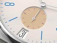 Nomos Glashütte Tangente 38 Datum "175 Years Watchmaking - Schulhausweiß" Handaufzug Edelstahl cremeweißes Zifferblatt graues Textilband Glasboden – Herrenuhren Uhr mit Datum aus Edelstahl. Das Gehäuse ist rund und silber. Das Textilarmband ist grau. Das Zifferblatt ist arabisch Index und beige. – Ansicht 5