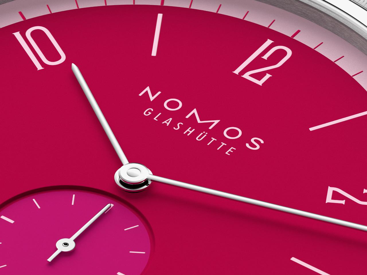 Nomos Glashütte Tangente 38 Datum "175 Years Watchmaking - Chili" Handaufzug Edelstahl pinkes Zifferblatt graues Textilband Glasboden – Herrenuhren Uhr mit Datum aus Edelstahl. Das Gehäuse ist rund und silber. Das Textilarmband ist grau. Das Zifferblatt ist arabisch Index und pink. – Ansicht 5