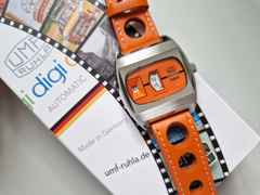 UMF Ruhla Scheibenuhr Automatik mit springender Stunde Edelstahl 41mm oranges Zifferblatt oranges Lederband limitiert – Herrenuhren Uhr ohne Datum aus Edelstahl, Keramik und Leder. Das Gehäuse ist tonneauform und silber. Das Lederarmband ist orange. Das Zifferblatt ist digital und orange. – Ansicht 3