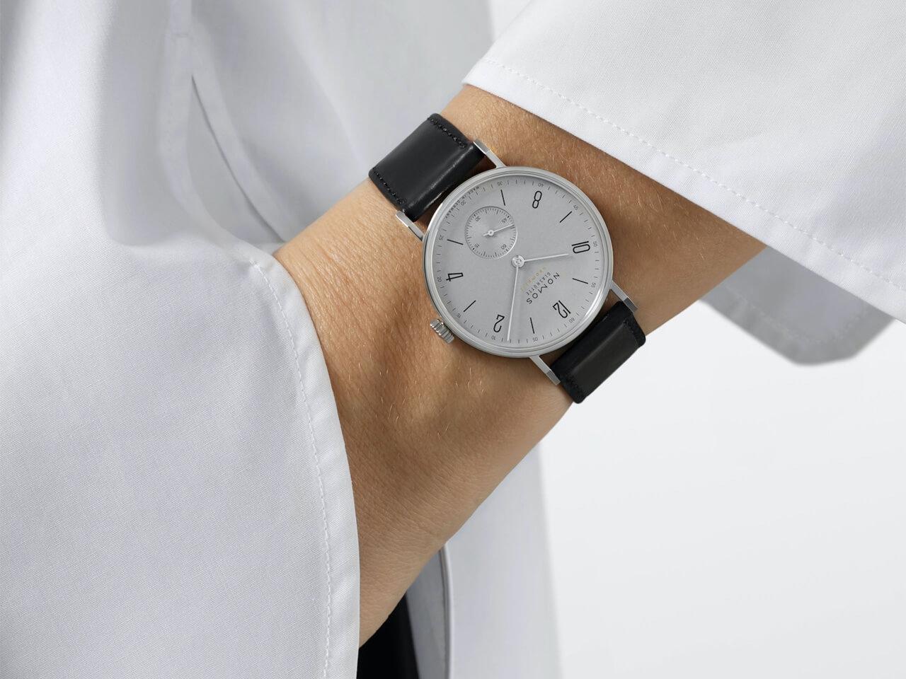 Nomos Glashütte Tangente 35 neomatik Platingrau Automatik Edelstahl 35mm graues Zifferblatt schwarzes Lederband Glasboden – Damenuhren Uhr ohne Datum aus Edelstahl. Das Gehäuse ist rund und silber. Das Lederarmband ist schwarz. Das Zifferblatt ist arabisch Index und silber. – Ansicht 5