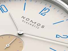 Nomos Glashütte Tangente 38 Datum "175 Years Watchmaking - Schulhausweiß" Handaufzug Edelstahl cremeweißes Zifferblatt graues Textilband Glasboden – Herrenuhren Uhr mit Datum aus Edelstahl. Das Gehäuse ist rund und silber. Das Textilarmband ist grau. Das Zifferblatt ist arabisch Index und beige. – Ansicht 6