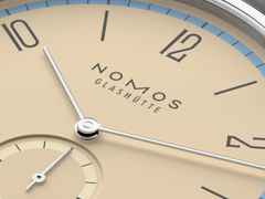 Nomos Glashütte Tangente 38 Datum "175 Years Watchmaking - Ariel" Handaufzug Edelstahl sandfarbenes Zifferblatt graues Textilband Glasboden – Herrenuhren Uhr mit Datum aus Edelstahl. Das Gehäuse ist rund und silber. Das Textilarmband ist grau. Das Zifferblatt ist arabisch Index und beige. – Ansicht 5