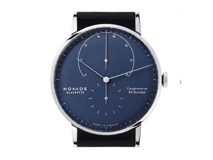 Nomos Glashütte Lambda 42 Tiefblau Handaufzug Weißgold 42mm blaues Zifferblatt schwarzes Lederband – Herrenuhren Uhr ohne Datum aus 750 Weißgold und Leder. Das Gehäuse ist rund und silber. Das Lederarmband ist schwarz. Das Zifferblatt ist ein Index in blau. – Ansicht 2