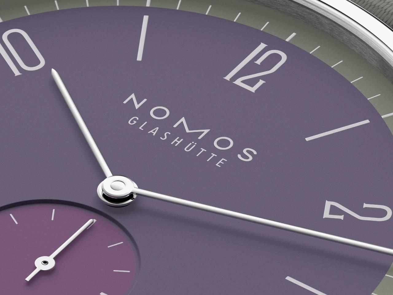 Nomos Glashütte Tangente 38 Datum "175 Years Watchmaking - Mauvegrün" Handaufzug Edelstahl violettes Zifferblatt graues Textilband Glasboden – Herrenuhren Uhr mit Datum aus Edelstahl. Das Gehäuse ist rund und silber. Das Textilarmband ist grau. Das Zifferblatt ist arabisch Index und lila. – Ansicht 6