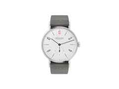 Nomos Glashütte Tangente 38 – 50 ans de Médecins Sans Frontières Limited Edition Handaufzug Edelstahl 38mm weißes Zifferblatt graues Textilband Stahlboden – Herrenuhren Uhr ohne Datum aus Edelstahl und Leder. Das Gehäuse ist rund und silber. Das Textilarmband ist schwarz. Das Zifferblatt ist arabisch Index und weiß.