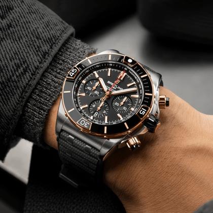 Breitling Super Chronomat B01 44 Automatik Edelstahl schwarzes Zifferblatt schwarzes Kautschukband – Herrenuhren Chronograph aus 950 Platin und Edelstahl. Das Gehäuse ist rund und silber-roségold. Das Kautschuk / Kunststoff / Silikon Armband ist schwarz. Das Zifferblatt ist ein Index in schwarz. – Ansicht 5