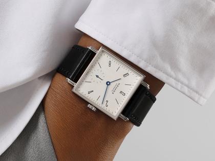 Nomos Glashütte Tetra 27 Weiss Handaufzug Edelstahl 27mm weißes Zifferblatt schwarzes Lederband Stahlboden – Damenuhren Uhr ohne Datum aus Edelstahl und Leder. Das Gehäuse ist quadratisch und silber. Das Lederarmband ist schwarz. Das Zifferblatt ist arabisch Index und weiß. – Ansicht 7