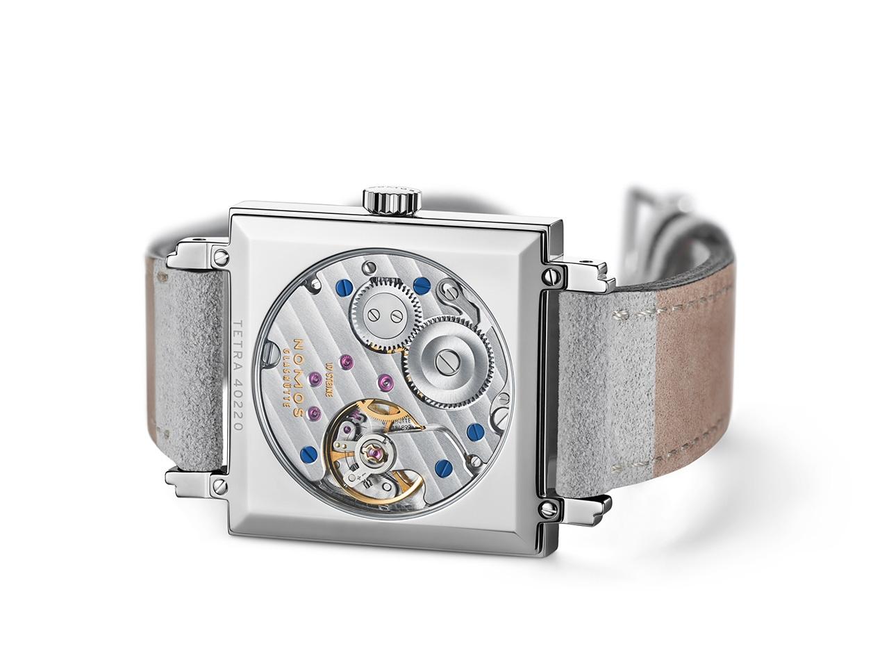 Nomos Glashütte Tetra Petit Four Perle Handaufzug Edelstahl 29mm rosafarbenes Zifferblatt graues Lederband Glasboden – Damenuhren Uhr ohne Datum aus Edelstahl. Das Gehäuse ist quadratisch und silber. Das Lederarmband ist grau. Das Zifferblatt ist arabisch Index und rosa. – Ansicht 6