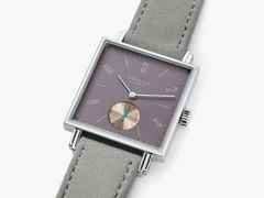 Nomos Glashütte Tetra Die Fuchsteufelswilde Handaufzug Edelstahl 29mm violettes Zifferblatt graues Veloursband Glasboden – Damenuhren Uhr ohne Datum aus Edelstahl und Leder. Das Gehäuse ist quadratisch und silber. Das Lederarmband ist grau. Das Zifferblatt ist arabisch Index und lila. – Ansicht 3
