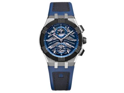 Maurice Lacroix Aikonic Chronograph Automatik Edelstahl 43mm skelettiertes Zifferblatt blaues Kautschukband – Herrenuhren Chronograph aus Edelstahl, Kautschuk und Keramik. Das Gehäuse ist rund und silber. Das Kautschuk / Kunststoff / Silikon Armband ist blau. Das Zifferblatt ist skelettiert und blau.