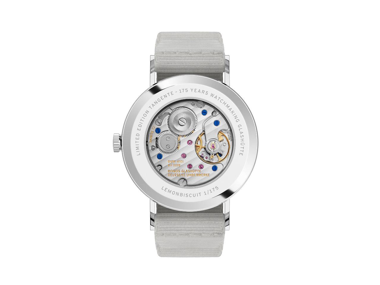 Nomos Glashütte Tangente 38 Datum "175 Years Watchmaking - Lemonbiscuit" Handaufzug Edelstahl cremeweißes Zifferblatt graues Textilband Glasboden – Herrenuhren Uhr mit Datum aus Edelstahl. Das Gehäuse ist rund und silber. Das Textilarmband ist grau. Das Zifferblatt ist arabisch Index und beige. – Ansicht 2