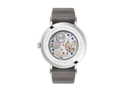 Nomos Glashütte Tangente 38 Datum "175 Years Watchmaking - Schneesturm" Handaufzug Edelstahl cremeweißes Zifferblatt graues Textilband Glasboden – Herrenuhren Uhr mit Datum aus Edelstahl. Das Gehäuse ist rund und silber. Das Textilarmband ist grau. Das Zifferblatt ist arabisch Index und beige. – Ansicht 2