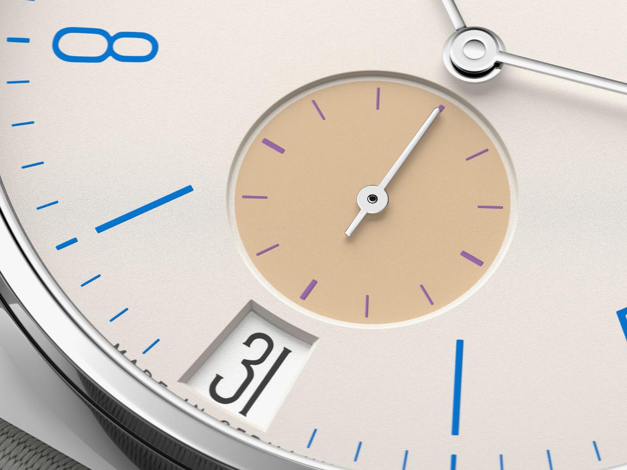 Nomos Glashütte Tangente 38 Datum "175 Years Watchmaking - Schulhausweiß" Handaufzug Edelstahl cremeweißes Zifferblatt graues Textilband Glasboden – Herrenuhren Uhr mit Datum aus Edelstahl. Das Gehäuse ist rund und silber. Das Textilarmband ist grau. Das Zifferblatt ist arabisch Index und beige. – Ansicht 5