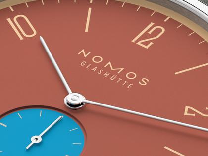 Nomos Glashütte Tangente 38 Datum "175 Years Watchmaking - Ziegelblau" Handaufzug Edelstahl rotes Zifferblatt graues Textilband Glasboden – Herrenuhren Uhr mit Datum aus Edelstahl. Das Gehäuse ist rund und silber. Das Textilarmband ist grau. Das Zifferblatt ist arabisch Index und rot. – Ansicht 5