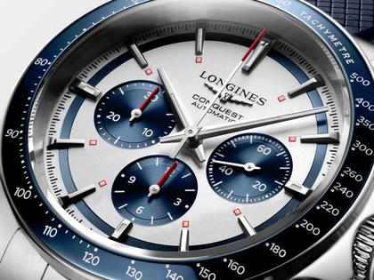 Longines Conquest Chronograph Automatik Edelstahl 42mm weiß-blaues Zifferblatt blaues Kautschukband – Herrenuhren Chronograph aus Edelstahl, Kautschuk und Keramik. Das Gehäuse ist rund und silber. Das Kautschuk / Kunststoff / Silikon Armband ist blau. Das Zifferblatt ist ein Index in weiß. – Ansicht 4