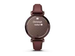 Garmin Lily 2 Smartwatch Aluminium eloxiert 35mm dunkelbronzefarbenes Display bordeauxfarbenes Lederband – Damenuhren Uhr Multifunktion aus eloxiertes Aluminium, Kunststoff und Leder. Das Gehäuse ist rund und rot. Das Lederarmband ist rot. Das Zifferblatt ist digital und rot. – Ansicht 3