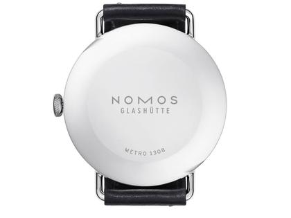 Nomos Glashütte Metro 38 Stadtschwarz Handaufzug Edelstahl 38mm schwarzes Zifferblatt schwarzes Lederband Stahlboden – Herrenuhren Uhr ohne Datum aus Edelstahl. Das Gehäuse ist rund und silber. Das Lederarmband ist schwarz. Das Zifferblatt ist arabisch Index und grau. – Ansicht 2