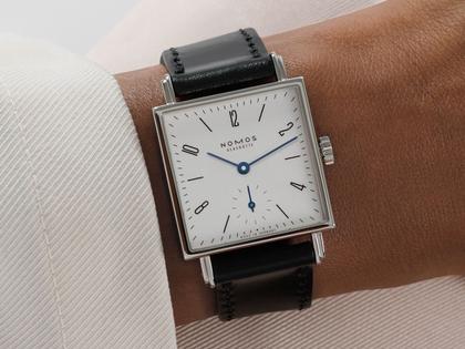 Nomos Glashütte Tetra 27 Weiss Handaufzug Edelstahl 27mm weißes Zifferblatt schwarzes Lederband Stahlboden – Damenuhren Uhr ohne Datum aus Edelstahl und Leder. Das Gehäuse ist quadratisch und silber. Das Lederarmband ist schwarz. Das Zifferblatt ist arabisch Index und weiß. – Ansicht 9