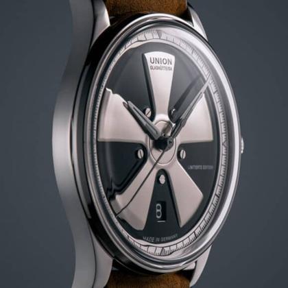 Union Glashütte Noramis Datum Deutschland Klassik 2023 Limitierte Edition Automatik Edelstahl 40mm Felgendesign Zifferblatt braunes Lederband – Herrenuhren Uhr mit Datum aus Edelstahl. Das Gehäuse ist rund und silber. Das Lederarmband ist braun. Das Zifferblatt ist ohne Zeichen und schwarz. – Ansicht 2
